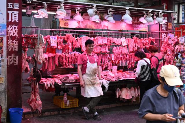 A butcher waits for customers on a market street in Hong Kong on March 31, 2026. (Photo by Peter PARKS / AFP)