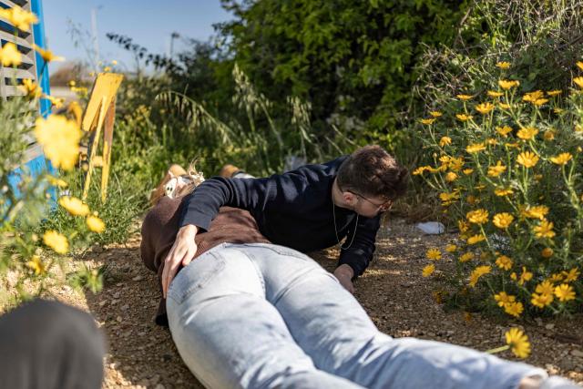 People take cover as missile-warning sirens sound in Shefayim near Tel-Aviv on March 31, 2026. The Middle East was sparked by joint US-Israeli strikes on Iran that triggered a wave of retaliatory missile and drone attacks against Israel and several other countries in the region. (Photo by Ilia YEFIMOVICH / AFP) / 