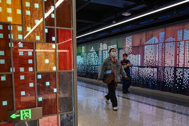 People walk inside a subway station in Shanghai on March 31, 2026. (Photo by Jade GAO / AFP)
