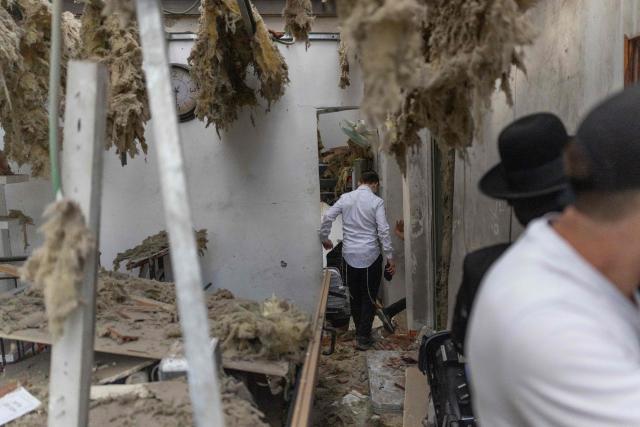 Ultra-Orthodox Jewish men assess the damage inside a house following an Iranian strike over Bnei Brak in central Israel on March 31, 2026. Iran fired missiles across the Middle East on March 31 as its capital was hit by fresh explosions, after US President Donald Trump threatened the country's key oil export hub, power stations and desalination plants. (Photo by Ilia YEFIMOVICH / AFP) / 
