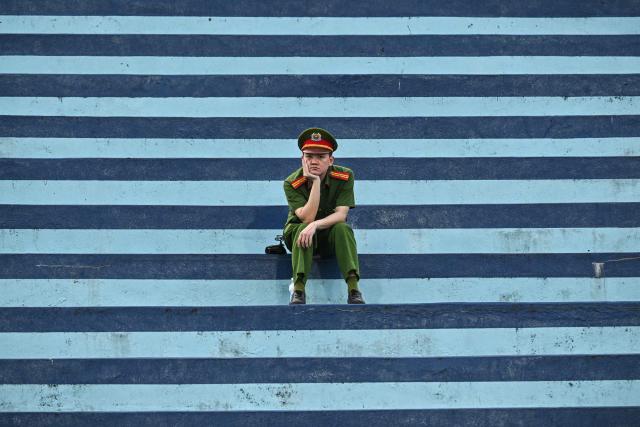 A police officer looks on as he sits before the AFC Asian Cup 2027 qualifiers football match between Vietnam and Malaysia at Thien Truong Stadium in Ninh Binh Province on March 31, 2026. (Photo by NHAC NGUYEN / AFP)