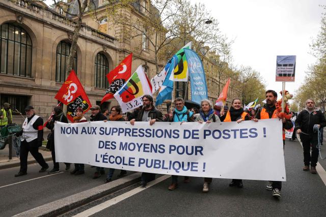 Protesters hold a banner reading "No to job cuts! Funding for public school!" during a teachers' during a teachers' demonstration to protest against teaching post cuts and classroom closures and demand higher wages as part of the national strike in the Education nationale in Paris on March 31, 2026. (Photo by Thomas SAMSON / AFP)