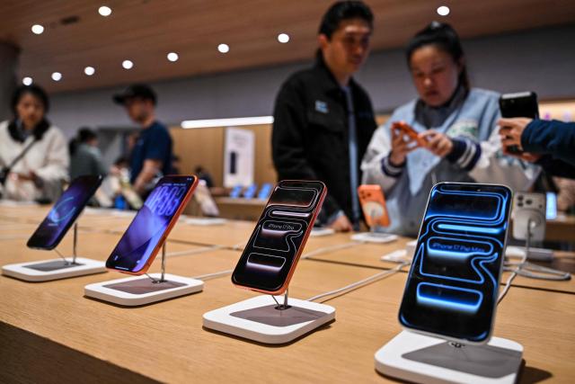 People visit an Apple store in Jing'an district in Shanghai on March 31, 2026. (Photo by HECTOR RETAMAL / AFP)