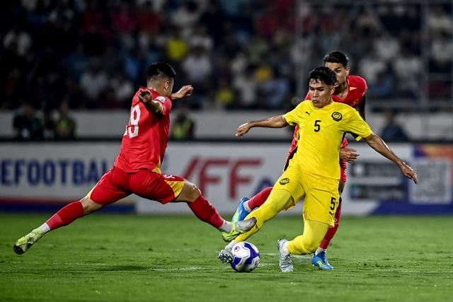 Malaysia's Ubaidullah Shamsul (R) fights for the ball with Vietnam's Nguyen Thanh Chung during the AFC Asian Cup qualifier Group F football match between Vietnam and Malaysia at the Thien Truong Stadium in Ninh Bình province on March 31, 2026. (Photo by Nhac NGUYEN / AFP)
