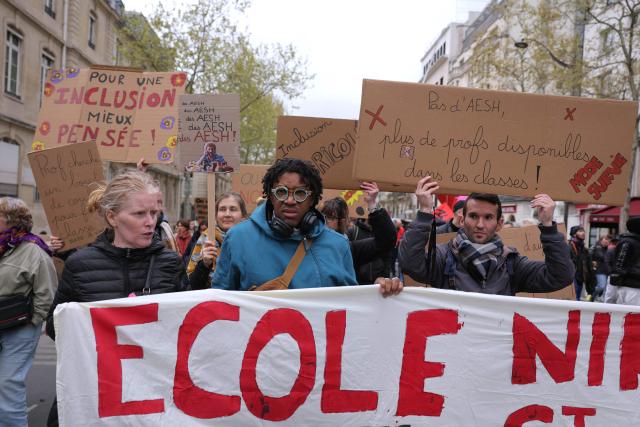 Protesters hold banners including some reading "For a better thaught inclusion!" (L) and "No AESH (Carers for pupils with disabilities), more available teachers in classrooms! Survival mode" (R) during a teachers' demonstration to protest against teaching post cuts and classroom closures and demand higher wages as part of the national strike in the Education nationale in Paris on March 31, 2026. (Photo by Thomas SAMSON / AFP)