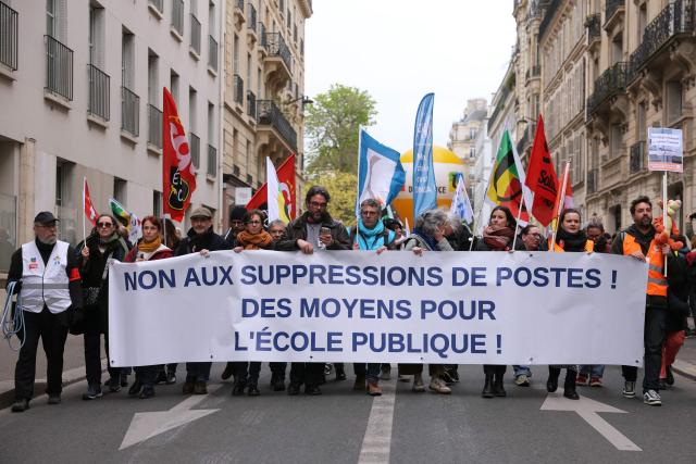 Protesters hold a banner reading "No to job cuts! Funding for public school!" during a teachers' demonstration to protest against teaching post cuts and classroom closures and demand higher wages as part of the national strike in the Education nationale in Paris on March 31, 2026. (Photo by Thomas SAMSON / AFP)