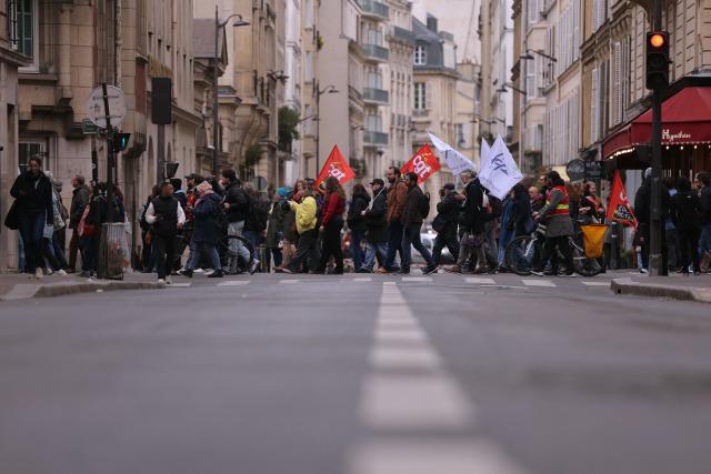 Protesters hold union flags as they march during a teachers' demonstration to protest against teaching post cuts and classroom closures and demand higher wages as part of the national strike in the Education nationale in Paris on March 31, 2026. (Photo by Thomas SAMSON / AFP)