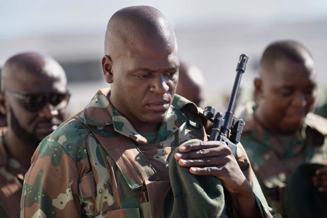 A member of the South African National Defence Force (SANDF) bows his head to pray as they take part in a parade in Belhar in Cape Town on March 31, 2026. This parade forms the final part of the preparations for the SANDF to play a supporting role to the SAPS in crime prevention operations, under the name of Operation Prosper. (Photo by RODGER BOSCH / AFP)