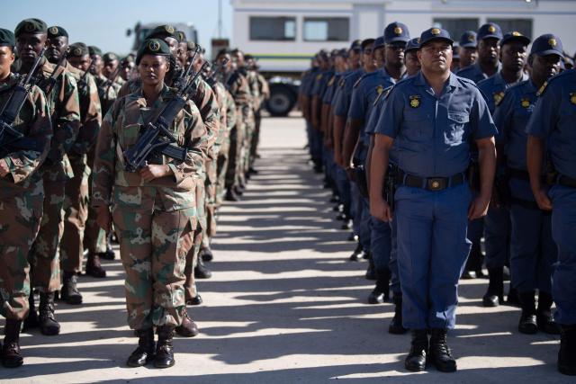 Members of the South African National Defence Force (SANDF) and the South African Police Service (SAPS) take part in a parade in Belhar in Cape Town on March 31, 2026. This parade forms the final part of the preparations for the SANDF to play a supporting role to the SAPS in crime prevention operations, under the name of Operation Prosper. (Photo by RODGER BOSCH / AFP)