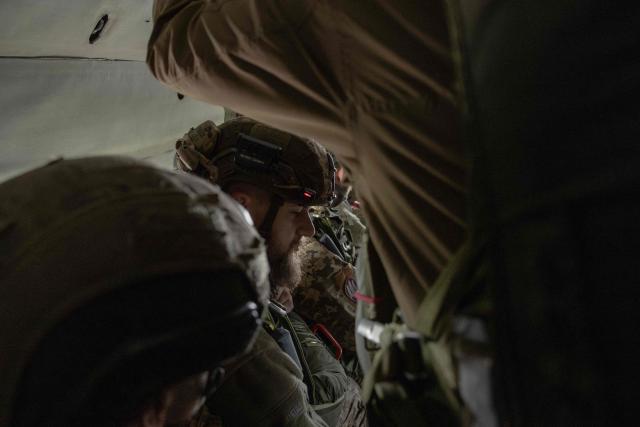 Ukrainian servicemen of the Air Assault Forces aboard a Mi-8 helicopter prepare for a parachute jump training, in an undisclosed location on March 27, 2026, amid the Russian invasion of Ukraine. The Air Assault Forces is a separate branch of the Armed Forces of Ukraine, whose main purpose is to rapidly respond to military threats and conduct swift offensive and defensive operations. It was specifically Air Assault units that were among the first to be deployed in operations such as the Kursk operation and the Kharkiv counteroffensive. Ukraine is preparing key changes to the mobilisation process, along with improved contracts and pay for infantry and assault troops, in an effort to recruit more people into the army. (Photo by Roman PILIPEY / AFP)