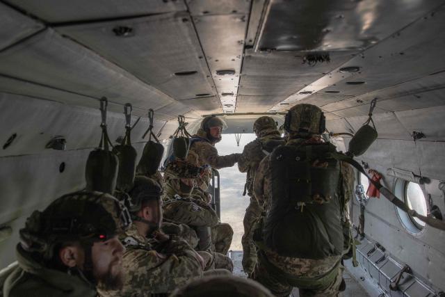 Ukrainian servicemen of the Air Assault Forces aboard a Mi-8 helicopter conduct a parachute jump training, in an undisclosed location on March 27, 2026, amid the Russian invasion of Ukraine. The Air Assault Forces is a separate branch of the Armed Forces of Ukraine, whose main purpose is to rapidly respond to military threats and conduct swift offensive and defensive operations. It was specifically Air Assault units that were among the first to be deployed in operations such as the Kursk operation and the Kharkiv counteroffensive. Ukraine is preparing key changes to the mobilisation process, along with improved contracts and pay for infantry and assault troops, in an effort to recruit more people into the army. (Photo by Roman PILIPEY / AFP)