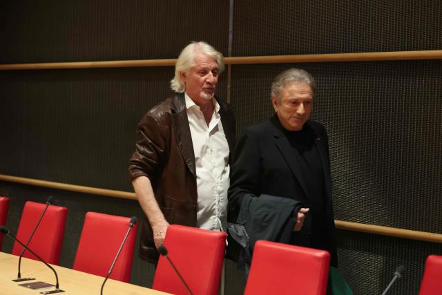 French TV host Patrick Sebastien (L) and French TV host Michel Drucker arrive to attend a hearing before the parliamentary commission of inquiry into the neutrality, functioning and financing of public broadcasting at the National Assembly in Paris on March 31, 2026. (Photo by Alain JOCARD / AFP)