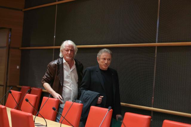 French TV host Patrick Sebastien (L) and French TV host Michel Drucker arrive to attend a hearing before the parliamentary commission of inquiry into the neutrality, functioning and financing of public broadcasting at the National Assembly in Paris on March 31, 2026. (Photo by Alain JOCARD / AFP)