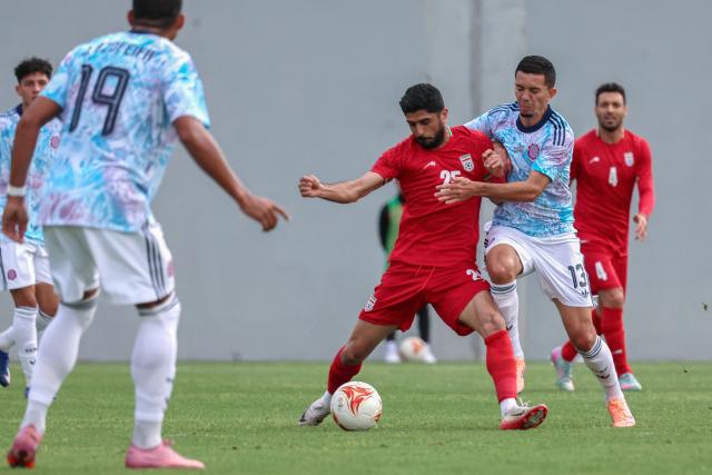 Iran's midfielder #28 Amirmohammad Razzaghinia fights for the ball with Costa Rica's midfielder #13 Jefferson Brenes during a friendly football match between Iran and Costa Rica, in Antalya, southern Turkey, on March 31, 2026. FIFA's president told AFP that Iran "will be at the World Cup" despite the Middle East war. (Photo by Adem ALTAN / AFP)