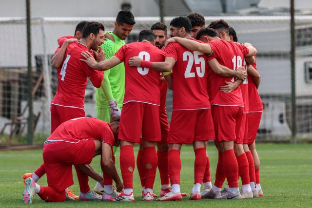 Iran's players gather on the pitch before a friendly football match between Iran and Costa Rica, in Antalya, southern Turkey, on March 31, 2026. FIFA's president told AFP that Iran "will be at the World Cup" despite the Middle East war. (Photo by ADEM ALTAN / AFP)