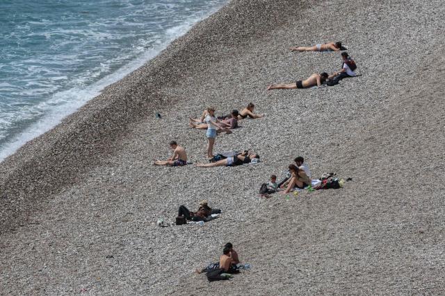 People sunbath on Konyaalti beach in Antalya, southern Turkey, on March 30, 2026. Turkey will host the 2026 United Nations Climate Change Conference COP31 at Antalya Expo Center in the southern Turkish resort of Antalya from 9 to 20 November, 2026. (Photo by Adem ALTAN / AFP)