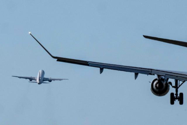 Commercial passenger planes land (R) and take off (L) on runway 19 at Reagan National Airport (DCA) in Washington, DC, on March 31, 2026. Nearly one year after the midair collision between a Bombardier CRJ700 airliner operating as American Airlines Flight 5342 and a US military Sikorsky UH-60 helicopter, one third of the controller positions in the tower are unfilled, according to figures from the FAA. (Photo by Ken CEDENO / AFP)