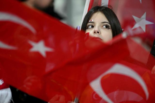 A supporter of Turkey national football team looks on behind turkish flags ahead of the FIFA World Cup 2026 European qualification final football match between Kosovo and Turkey at the Fadil Vokrri stadium in Pristina on March 31, 2026. (Photo by Armend NIMANI / AFP)