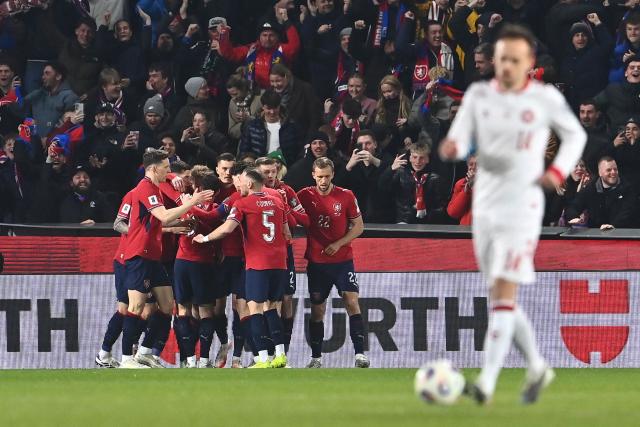 Czech Republic's midfielder #15 Pavel Sulc (hidden) is celebrated by team mates after scoring the opening goal 1-0 during the FIFA World Cup 2026 European qualification final football match Czech Republic vs Denmark on March 31, 2026 in Prague, Czech Republic. (Photo by Michal Cizek / AFP)