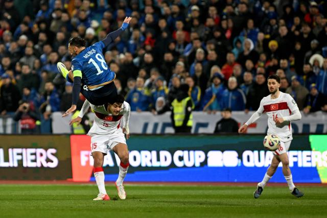 Kosovo's forward #18 Vedat Muriqi and Turkey's defender #15 Ozan Kabak fight for the ball during the FIFA World Cup 2026 European qualification final football match between Kosovo and Turkey at the Fadil Vokrri stadium in Pristina on March 31, 2026. (Photo by Armend NIMANI / AFP)