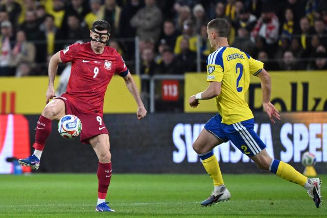 Poland's forward #09 Robert Lewandowski and Sweden's defender #02 Gustaf Lagerbielke vie for the ball during the FIFA World Cup 2026 European qualification final football match between Sweden and Poland in Solna, Sweden, on March 31, 2026. (Photo by Jonathan Nackstrand / AFP)