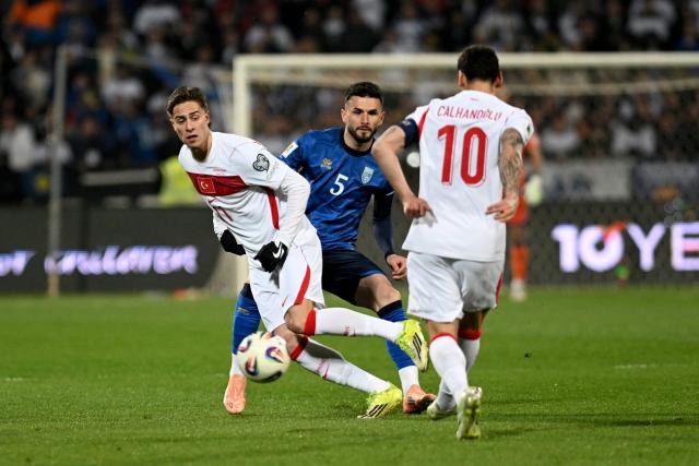 Turkey's forward #11 Kenan Yildiz (L) and Kosovo's midfielder #05 Lumbardh Dellova (C) fight for the ball during the FIFA World Cup 2026 European qualification final football match between Kosovo and Turkey at the Fadil Vokrri stadium in Pristina on March 31, 2026. (Photo by Armend NIMANI / AFP)
