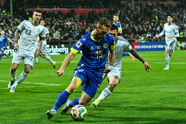 Bosnia-Herzegovina's midfielder #15 Amar Memic (L) fights for the ball with Italy's forward #07 Matteo Politano during the FIFA World Cup 2026 European qualification final football match between Bosnia-Herzegovina and Italy at the Bilino-Polje stadium in Zenica on March 31, 2026. (Photo by Elvis BARUKCIC / AFP)