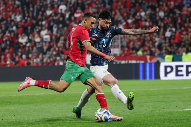 Morocco's Soufiane Rahimi (L) fights for the ball with Paraguay's Omar Alderete during the friendly football match between Marocco and Uruguay at the Stade Bollaert-Delelis in Lens, northern France on March 31, 2026. (Photo by Francois LO PRESTI / AFP)