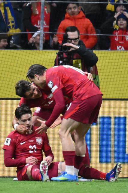 Poland's midfielder #21 Nicola Zalewski celebrates with team mates after scoring the equalising goal 1:1 during the FIFA World Cup 2026 European qualification final football match between Sweden and Poland in Solna, Sweden, on March 31, 2026. (Photo by Jonathan Nackstrand / AFP)
