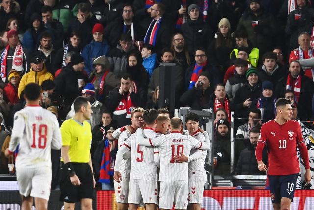 Denmark's defender #02 Joachim Andersen (hidden) is celebrated by team mates after scoring the equalizing goal 1-1 during the FIFA World Cup 2026 European qualification final football match Czech Republic vs Denmark on March 31, 2026 in Prague, Czech Republic. (Photo by Michal Cizek / AFP)