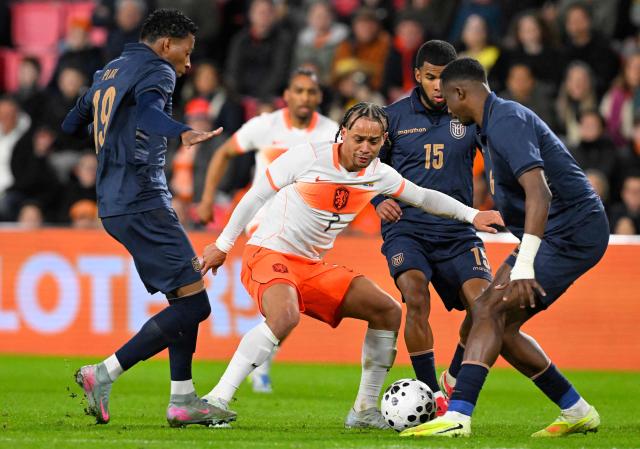 Netherlands' midfielder #07 Xavi Simons (C) and Ecuador's Defender #06 Willian Pacho (R) fight for the ball during the friendly international football match between the Netherlands and Ecuador at the PSV Stadium in Eindhoven on March 31, 2026. (Photo by JOHN THYS / AFP)