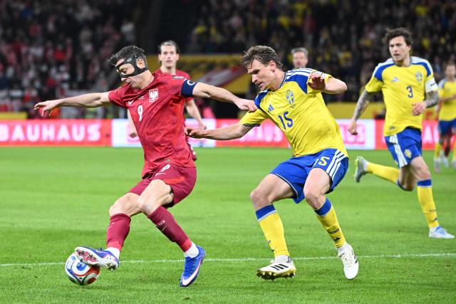Poland's forward #09 Robert Lewandowski and Sweden's defender #15 Carl Starfelt vie for the ball during the FIFA World Cup 2026 European qualification final football match between Sweden and Poland in Solna, Sweden, on March 31, 2026. (Photo by Jonathan Nackstrand / AFP)
