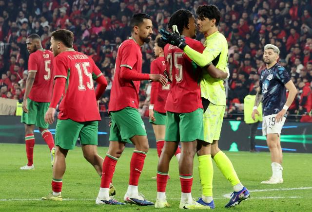 Morocco's players celebrate after winning the friendly football match between Morocco and Paraguay at the Stade Bollaert-Delelis in Lens, northern France on March 31, 2026. (Photo by Francois LO PRESTI / AFP)