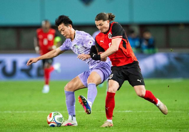 South Korea's defender #02 Lee Han-beom (L) and Austria's forward #09 Marcel Sabitzer vie for the ball during a friendly football match between Austria and South Korea in Vienna, Austria, on March 31, 2026. (Photo by GEORG HOCHMUTH / APA / AFP) / Austria OUT