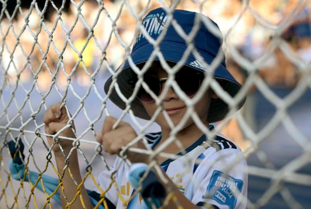 An Argentine boy watches from behind a fence ahead of a friendly football match between Argentina and Zambia at La Bombonera stadium in Buenos Aires on March 31, 2026. (Photo by JUAN MABROMATA / AFP)