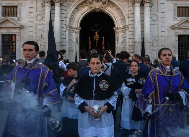 Penitents of the 'Los Estudiantes' brotherhood take part in a procession during Holy Week in Seville, Spain, on March 31 2026. Spain's colourful Holy Week celebrations started this week, featuring centuries-old processions of the faithful carrying flower-covered floats topped with statues of Christ or the Virgin Mary that draw huge crowds. Organised by various religious brotherhoods, or "confradias", the parades are held across the country in the week leading up to Easter Sunday, which this year in the Roman Catholic Church falls on April 5, 2026. (Photo by Cristina Quicler / AFP)