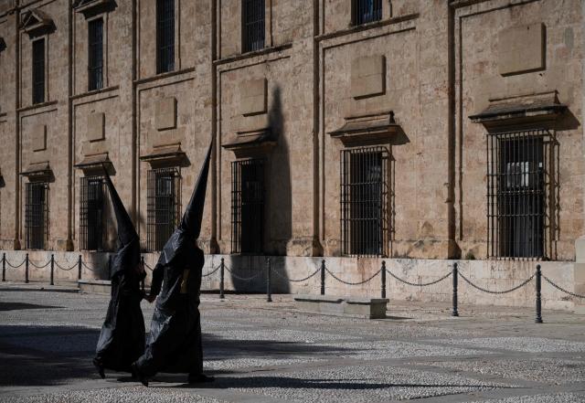 Penitents of the 'Los Estudiantes' brotherhood arrive to take part in a procession during Holy Week in Seville, Spain, on March 31 2026. Spain's colourful Holy Week celebrations started this week, featuring centuries-old processions of the faithful carrying flower-covered floats topped with statues of Christ or the Virgin Mary that draw huge crowds. Organised by various religious brotherhoods, or "confradias", the parades are held across the country in the week leading up to Easter Sunday, which this year in the Roman Catholic Church falls on April 5, 2026. (Photo by Cristina Quicler / AFP)