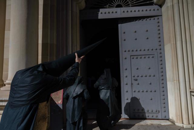 Penitents of the 'Los Estudiantes' brotherhood arrive to take part in a procession during Holy Week in Seville, Spain, on March 31 2026. Spain's colourful Holy Week celebrations started this week, featuring centuries-old processions of the faithful carrying flower-covered floats topped with statues of Christ or the Virgin Mary that draw huge crowds. Organised by various religious brotherhoods, or "confradias", the parades are held across the country in the week leading up to Easter Sunday, which this year in the Roman Catholic Church falls on April 5, 2026. (Photo by Cristina Quicler / AFP)