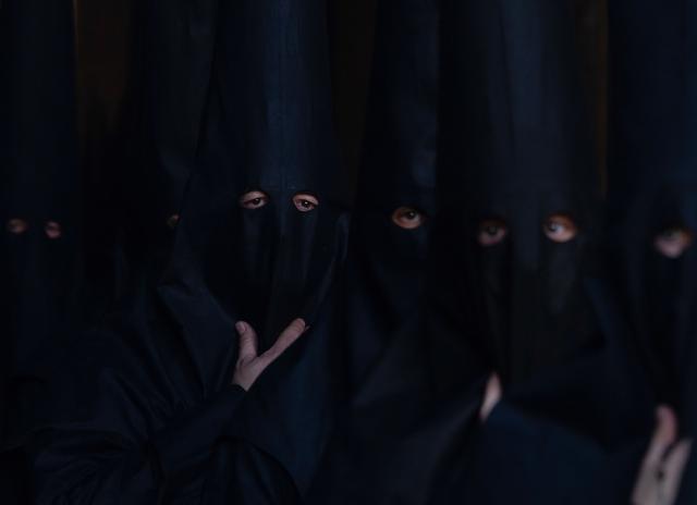 TOPSHOT - Penitents of the 'Los Estudiantes' brotherhood take part in a procession during Holy Week in Seville, Spain, on March 31 2026. Spain's colourful Holy Week celebrations started this week, featuring centuries-old processions of the faithful carrying flower-covered floats topped with statues of Christ or the Virgin Mary that draw huge crowds. Organised by various religious brotherhoods, or "confradias", the parades are held across the country in the week leading up to Easter Sunday, which this year in the Roman Catholic Church falls on April 5, 2026. (Photo by Cristina Quicler / AFP)