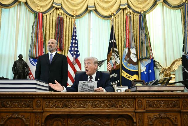 US President Donald Trump (R) speaks as Commerce Secretary Howard Lutnick (L) looks after he signed an executive order in the Oval Office of the White House in Washington, DC, on March 31, 2026. (Photo by Brendan SMIALOWSKI / AFP)
