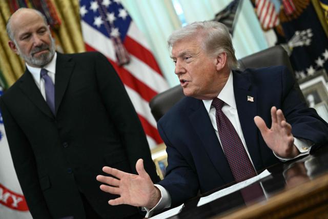 US President Donald Trump speaks as Commerce Secretary Howard Lutnick (L) looks on after he signed an executive order in the Oval Office of the White House in Washington, DC, on March 31, 2026. (Photo by Brendan SMIALOWSKI / AFP)