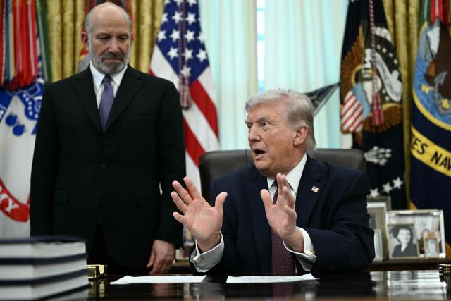 US President Donald Trump speaks as Commerce Secretary Howard Lutnick (L) looks on after he signed an executive order in the Oval Office of the White House in Washington, DC, on March 31, 2026. (Photo by Brendan SMIALOWSKI / AFP)