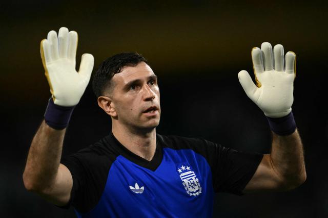Argentina's goalkeeper #23 Emiliano Martinez waves to supporters as he warms up ahead of a friendly football match between Argentina and Zambia at La Bombonera stadium in Buenos Aires on March 31, 2026. (Photo by Luis ROBAYO / AFP)