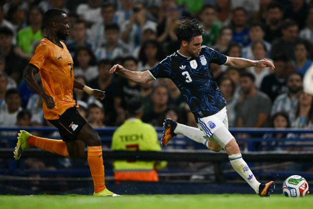 Argentina's defender #03 Nicolas Tagliafico (R) kicks the ball past Zambia's forward #07 Albert Kangwanda during a friendly football match between Argentina and Zambia at La Bombonera stadium in Buenos Aires on March 31, 2026. (Photo by Luis ROBAYO / AFP)