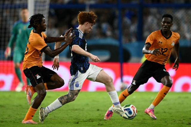 (L-R) Zambia's midfielder #25 Owen Tembo, Argentina's defender #06 Valentin Barco, and Zambia's midfielder #12 Wilson Chisala fight for the ball during a friendly football match between Argentina and Zambia at La Bombonera stadium in Buenos Aires on March 31, 2026. (Photo by Luis ROBAYO / AFP)