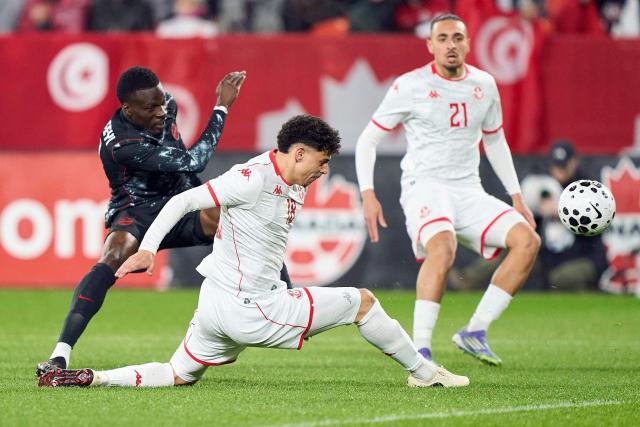 Tunisia's defender #18 Alaa Ghram (C) and Canada's forward #12 Tani Oluwaseyi (L) fight for the ball during a friendly football match between Canada and Tunisia at BMO Field in Toronto, Canada, on March 31, 2026. (Photo by Geoff Robins / AFP)