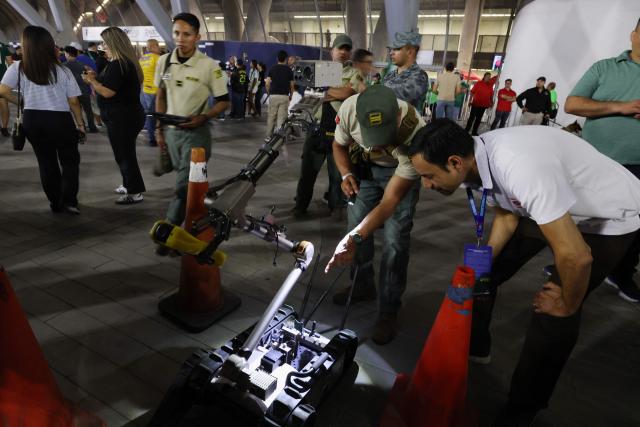 Security officers inspect a PackBot military robot, operated by Mexico's Secretariat of National Defense for detecting radiation and chemical agents, ahead of the 2026 FIFA World Cup qualifiers final playoff football match between Iraq and Bolivia at the BBVA Stadium in Guadalupe, Nuevo Leon state, Mexico, on March 31, 2026. (Photo by Julio Cesar AGUILAR / AFP)