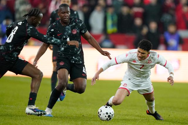 Tunisia's forward #07 Khalil Ayari looses his balance while trying to control the ball under pressure from Canada's defender #04 Kamal Miller (C) and Canada's midfielder #08 Ismael Kone during a friendly football match between Canada and Tunisia at BMO Field in Toronto, Canada, on March 31, 2026. (Photo by Geoff Robins / AFP)