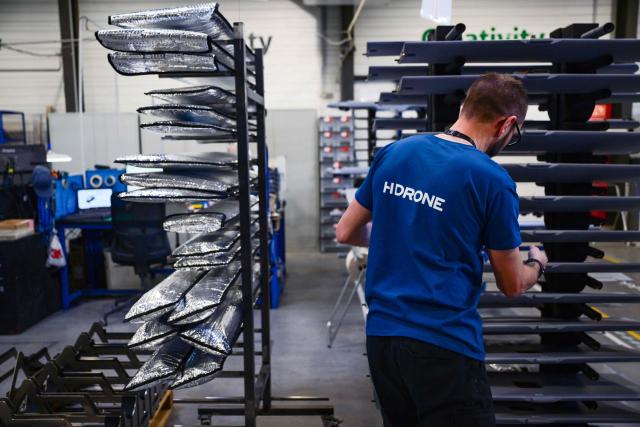 An employee handles drone parts at the Survey Copter factory, an Airbus subsidiary, in Pierrelatte, southern France on March 31, 2026. At Survey Copter, a French SME integrated into Airbus, the European aerospace corporation is leaning on its know-how in helicopters to develop drones — which have become the sinews of modern warfare — and to make them cooperate with manned aircraft. (Photo by OLIVIER CHASSIGNOLE / AFP)