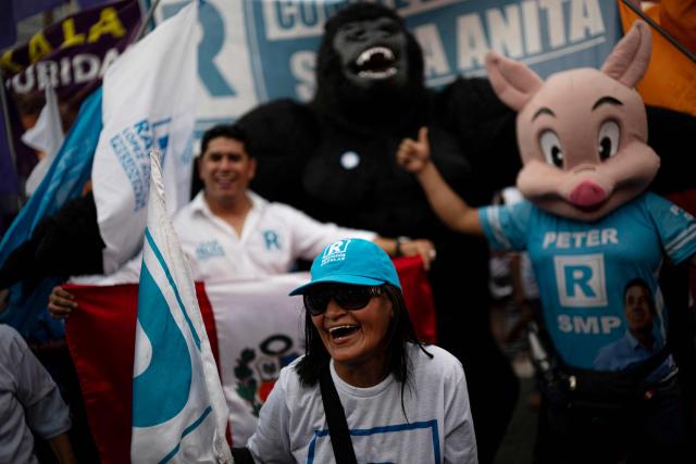 Supporters of Peru's presidential candidate Rafael Lopez Aliaga, for the Renovacion Popular party, are seen outside the Lima Convention Center during the second round of debates on education and employment in Lima on March 31, 2026. Peru will hold presidential elections on April 12. (Photo by ERNESTO BENAVIDES / AFP)